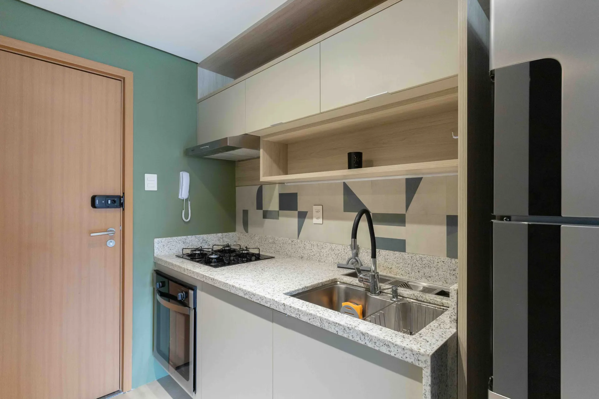 Cozinha completa com cooktop, forno e geladeira